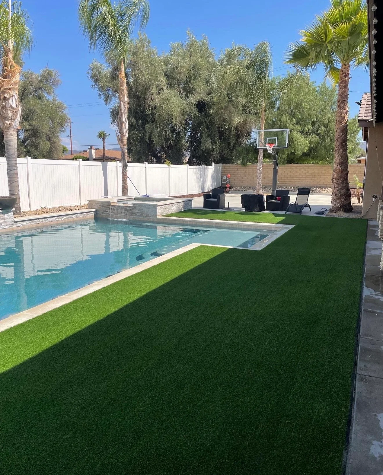 Backyard pool and spa with turf lawn and palm trees built by Rehab Building Co. INC
